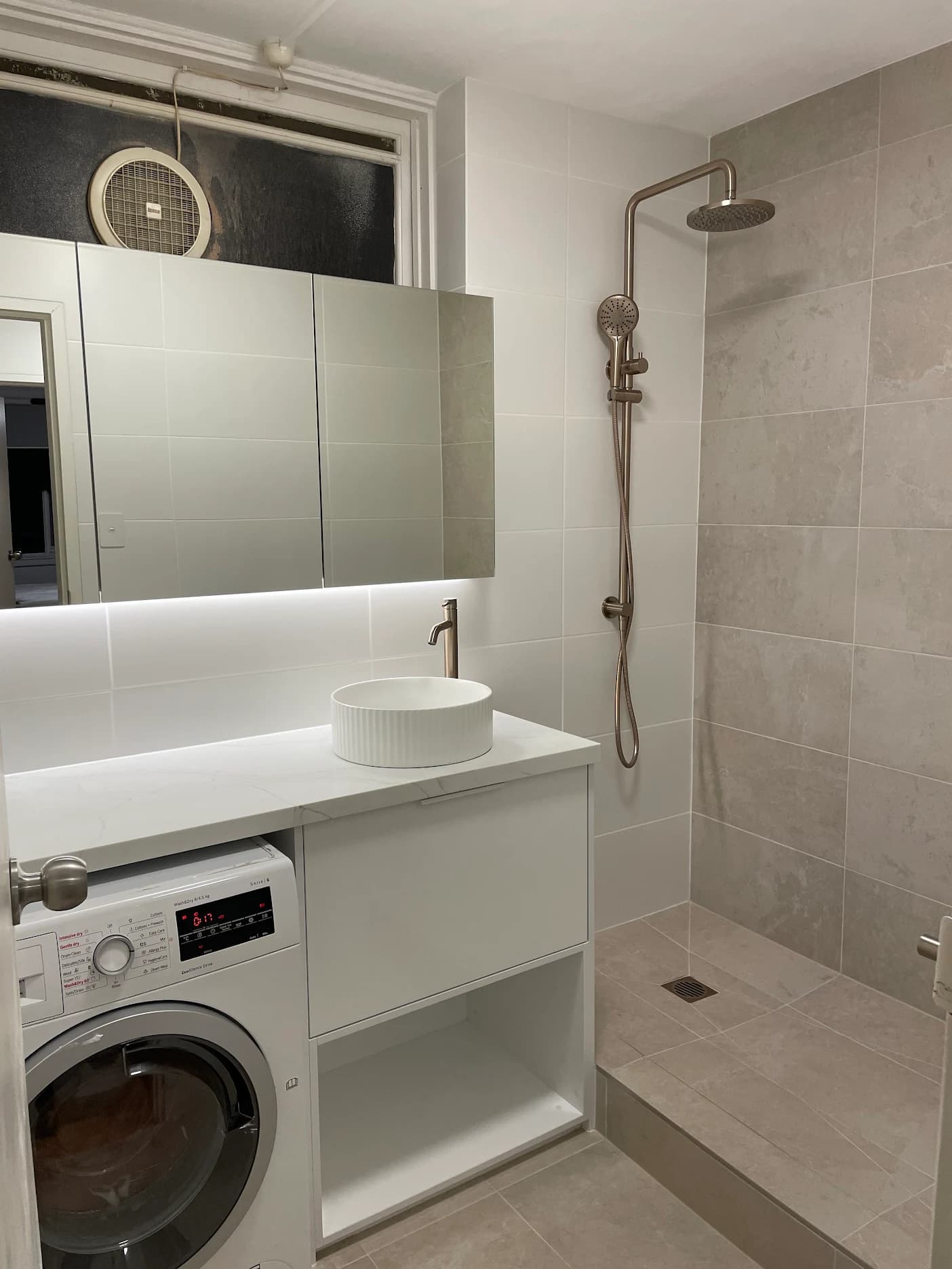 Bathroom vanity, round basin, mirrored cabinet, and shower with rain head and handheld shower